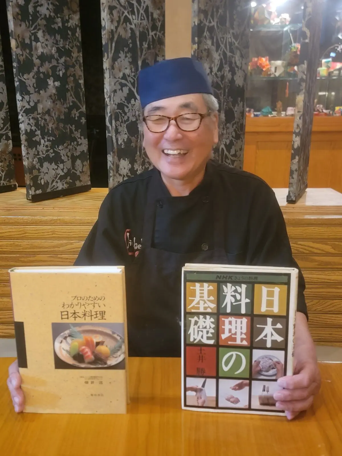 Fuji-san, Jinbeh's head sushi chef since 1993, with the traditional Japanese cookbooks that shaped his training