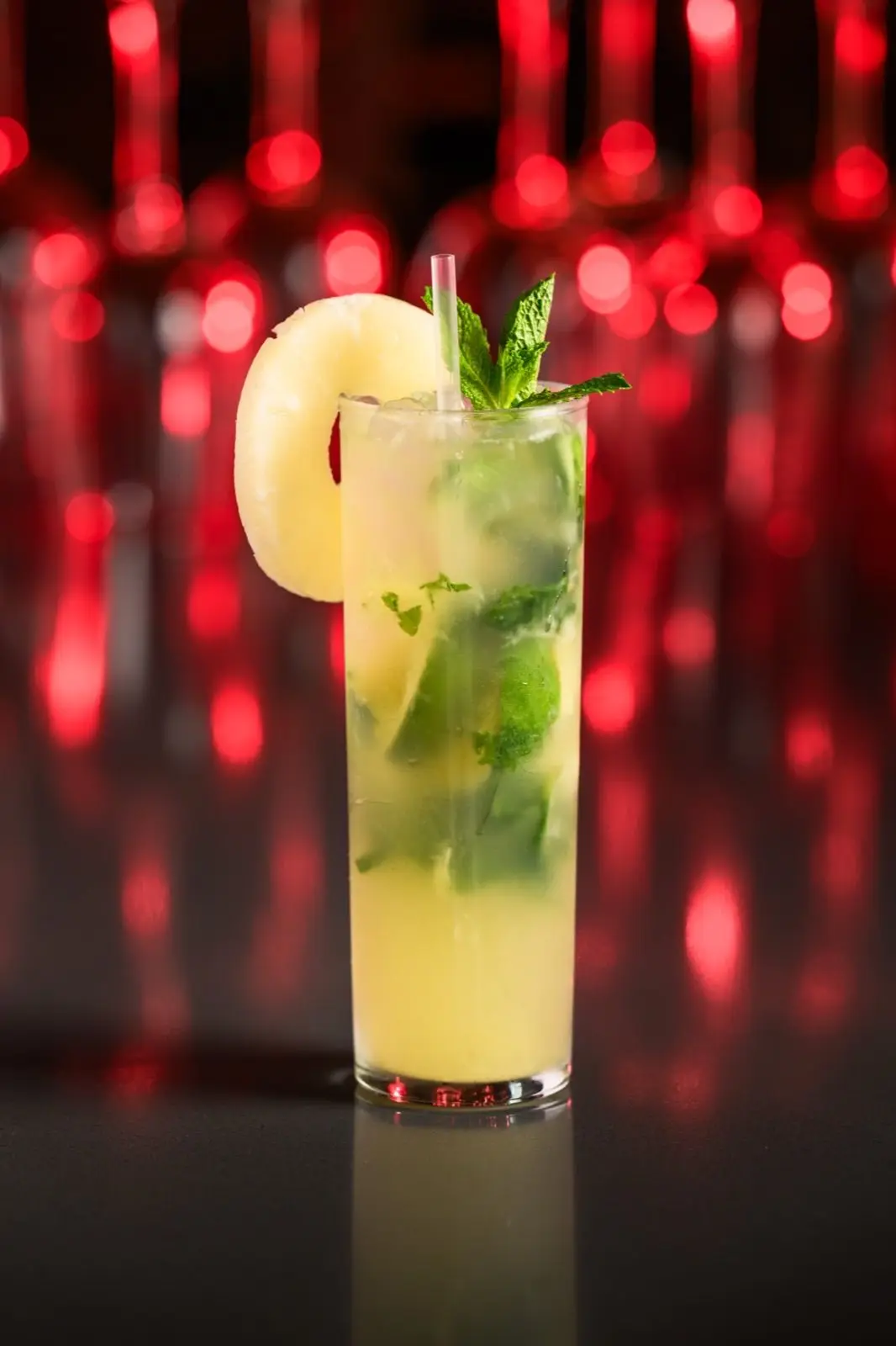 Refreshing pineapple-mint highball cocktail with pineapple wedge garnish