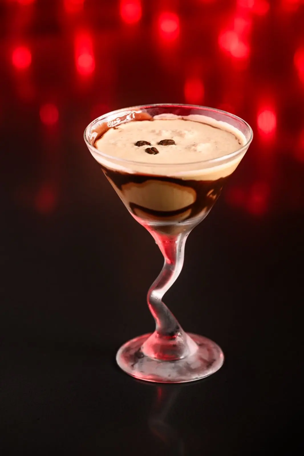 Jinbeh espresso martini with chocolate drizzle and floating coffee beans
