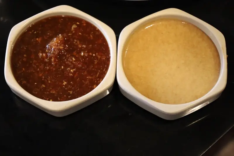 Jinbeh house-made dipping sauces — spicy chili sauce and signature yum yum sauce made fresh daily from scratch